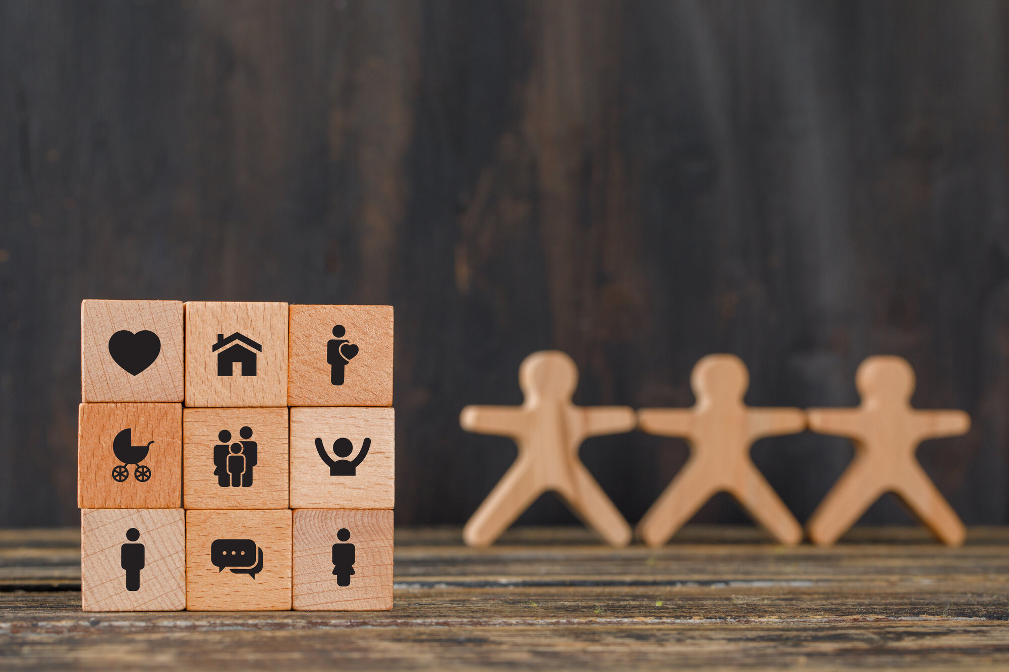 family-concept-with-icons-wooden-cubes-human-figures-wooden-table-side-view family-concept-with-icons-wooden-cubes-human-figures-wooden-table-side-view